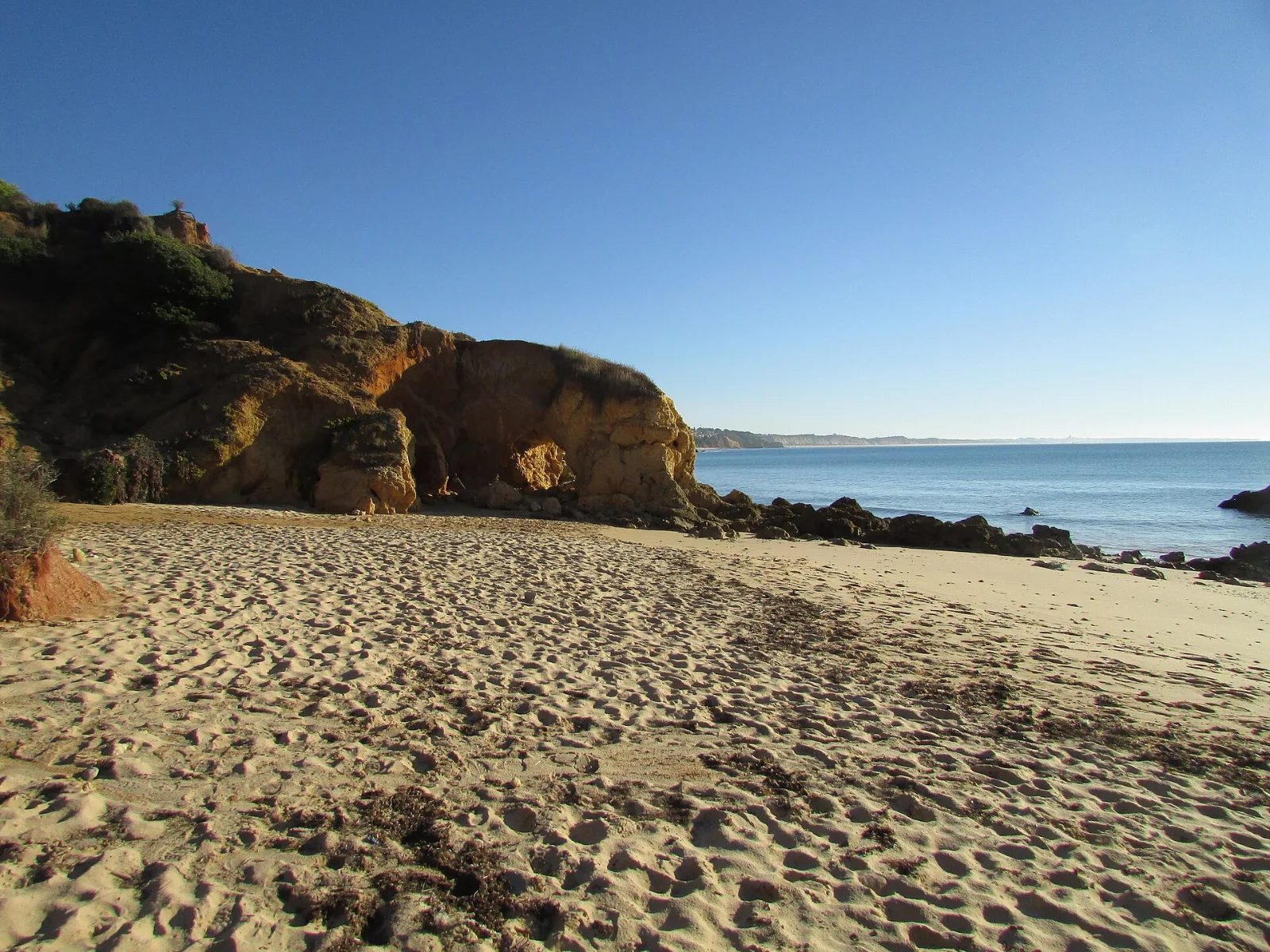 Golden rocks and calm sea at Praia de Santa Eulália, Albufeira